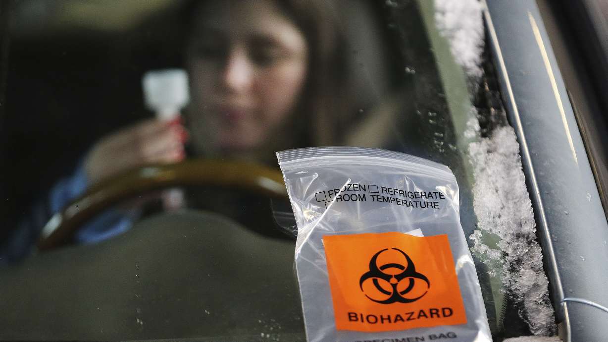 Sage Turek takes a COVID-19 saliva test at the Utah State Fairpark in Salt Lake City, where the University of Utah Health Wellness Bus set up shop on Tuesday, Dec. 15, 2020.