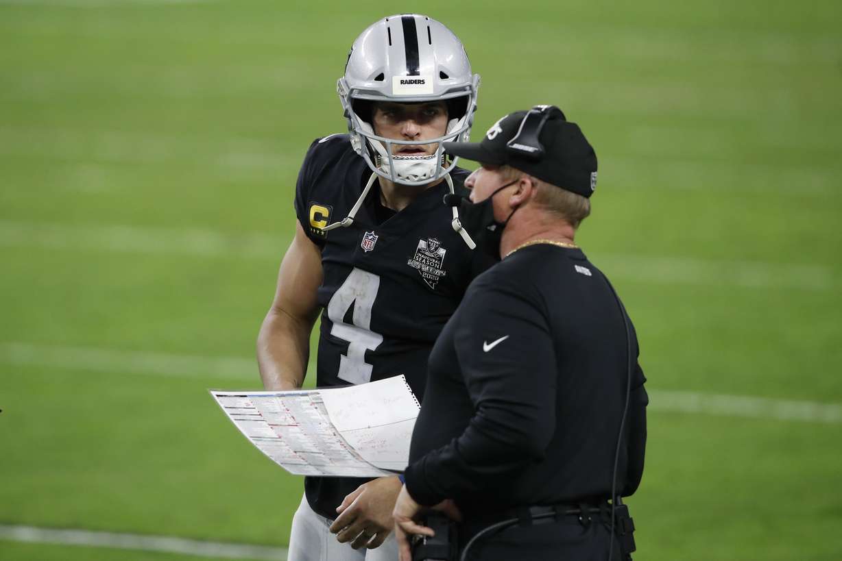 Las Vegas Raiders quarterback Derek Carr (4) speaks with head coach Jon Gruden during the second half of an NFL football game Miami Dolphins, Saturday, Dec. 26, 2020, in Las Vegas.