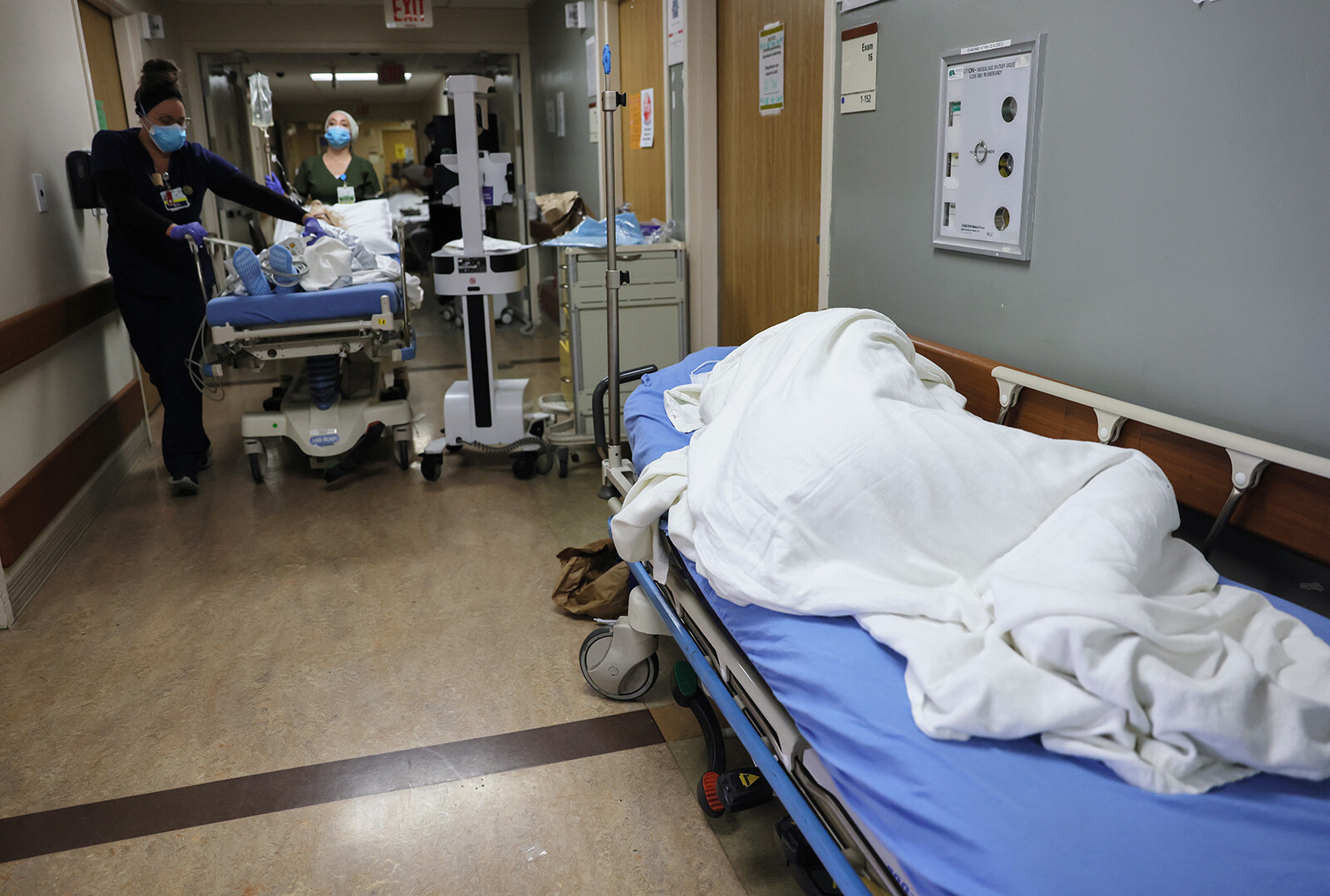 A patient lies on a stretcher in the hallway of the overloaded Emergency Room at Providence St. Mary Medical Center amid a surge in COVID-19 patients in Southern California on December 23, 2020 in Apple Valley, California.