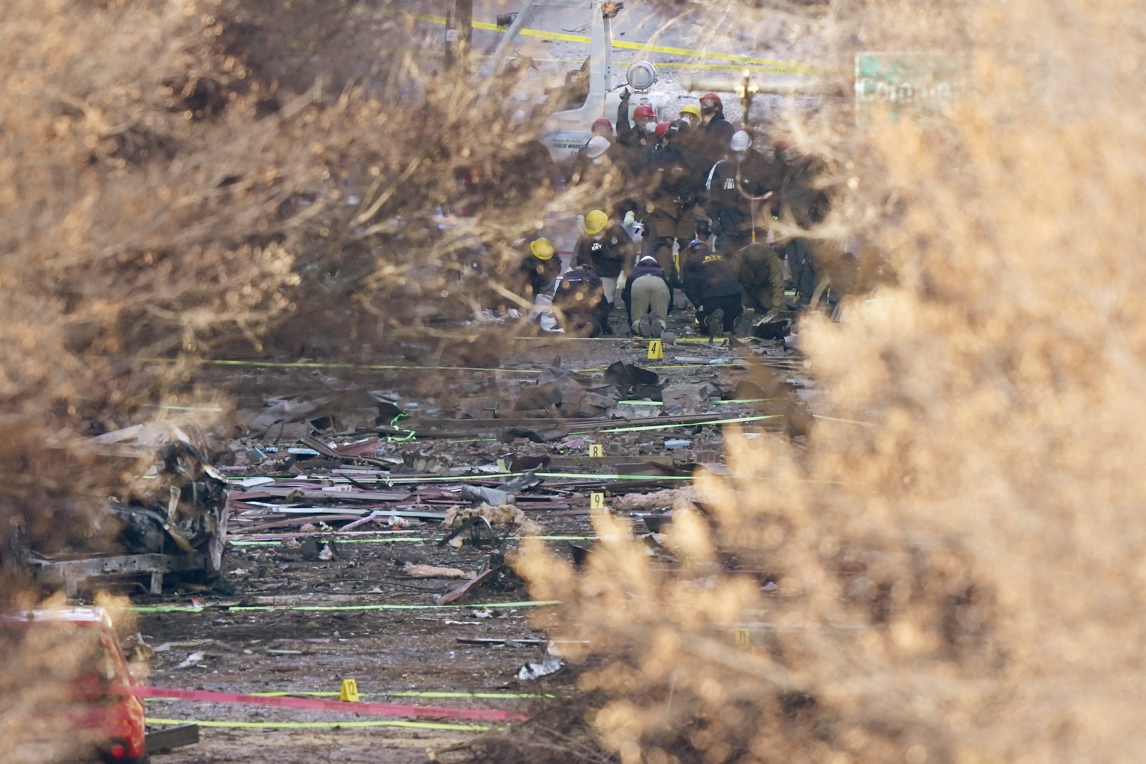 Investigators continue to look through the site of an explosion Monday, Dec. 28, 2020, in Nashville, Tenn.