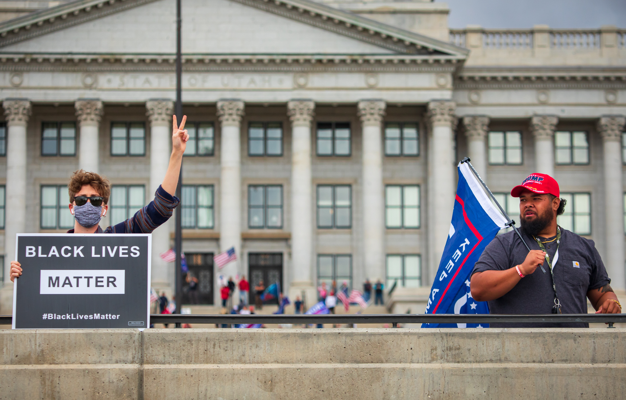 A Joe Biden supporter celebrates 2020 election results while standing near a Donald Trump supporter protesting election results at the Utah Capitol on Saturday, Nov. 7, 2020.
