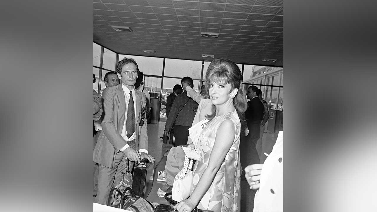 FILE - In this Sept.7, 1967 file photo, Italy's Gina Lollobrigida and French designer Pierre Cardin arrive at the Venice airport to attend the Venice International Film Festival. France's Academy of Fine Arts says famed fashion designer Pierre Cardin has died at 98