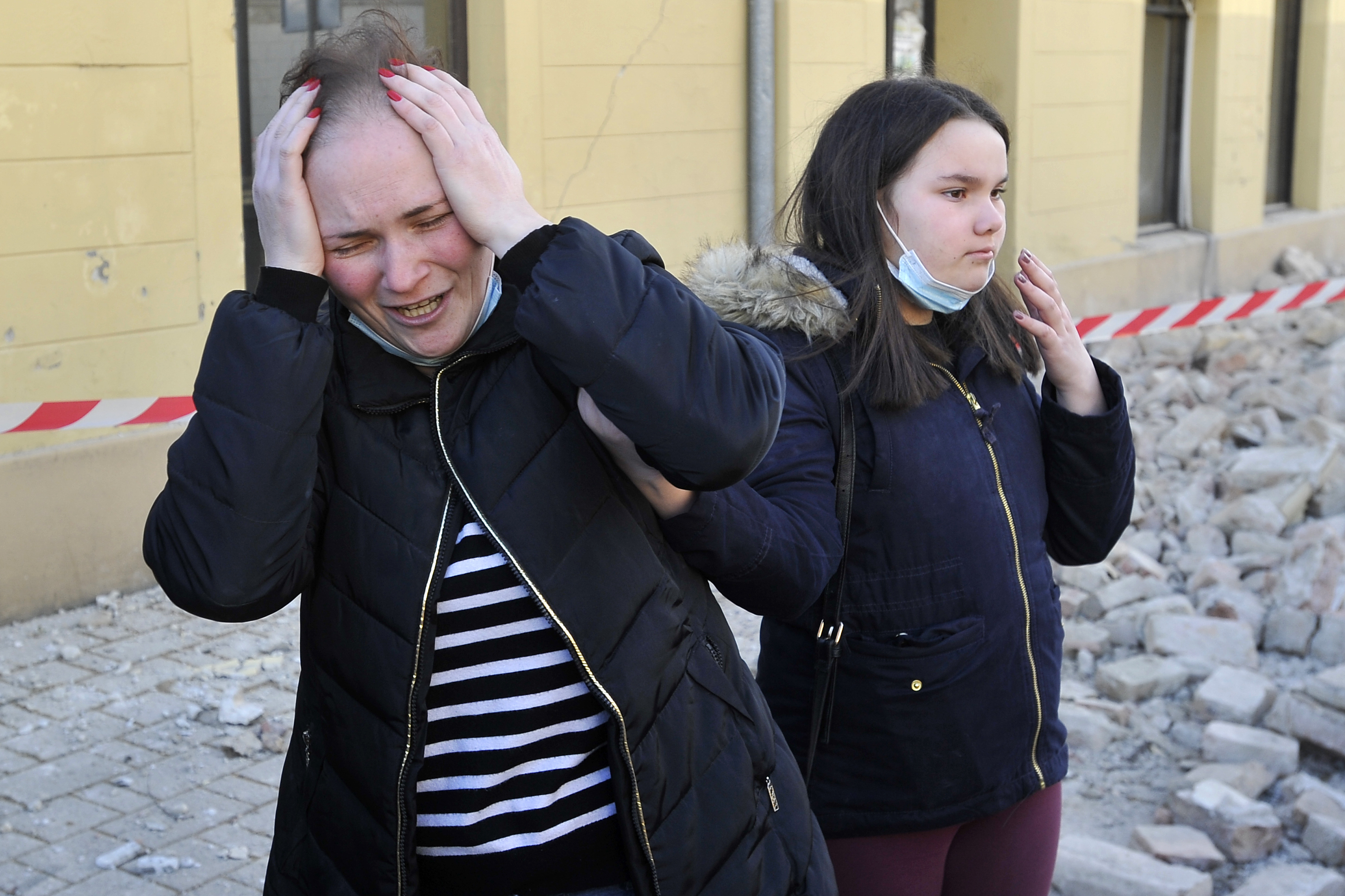 A woman reacts next to buildings damaged in an earthquake in Petrinja, Croatia, Tuesday, Dec. 29, 2020.