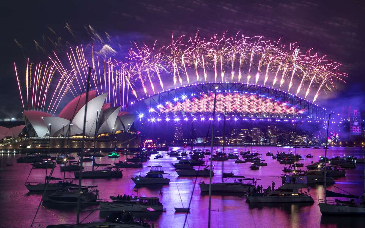 Fireworks explode over the Sydney Opera House and Harbour Bridge as New Year celebrations begin in Sydney, Australia, Thursday, Dec. 31, 2020. One million people would usually crowd the Sydney Harbor to watch the annual fireworks that center on the Sydney Harbour Bridge. But this year authorities advised revelers to watch the fireworks on television as the two most populous states, New South Wales and Victoria battle to curb new COVID-19 outbreaks.