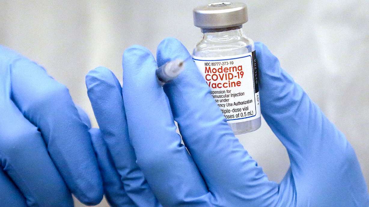 Shixian Wang, a pharmacist with Red Rock Pharmacy, fills a syringe with the Moderna COVID-19 vaccine in Salt Lake City on Dec. 29. Utah's COVID-19 surge showed no indication of slowing down Friday as 894 new cases were reported.