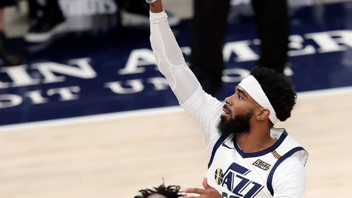 Utah Jazz guard Mike Conley (10) pushes up a shot over LA Clippers guard Patrick Beverley (21) as the Utah Jazz and LA Clippers play in an NBA basketball game at Vivint Smart Home Arena in Salt Lake City on Friday, Jan. 1, 2021.