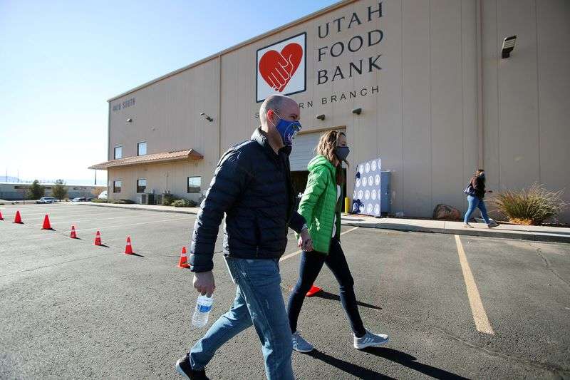 Gov.-elect Spencer Cox and his wife, Abby, walk to
their vehicle after they and Lt. Gov.-elect Deidre Henderson and
members of their families volunteered at the Utah Food Bank in St.
George on Saturday, Jan. 2, 2021.