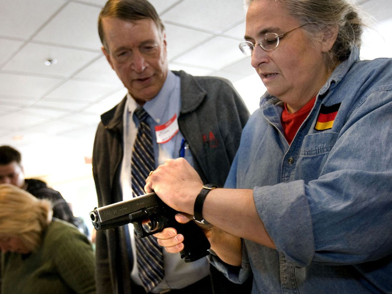 Tery Binkerd, right, holds a hand gun with assistance
from Jim McCarthy, a Utah Concealed Carry Permit Instructor, during
a free concealed carry class in 2012.