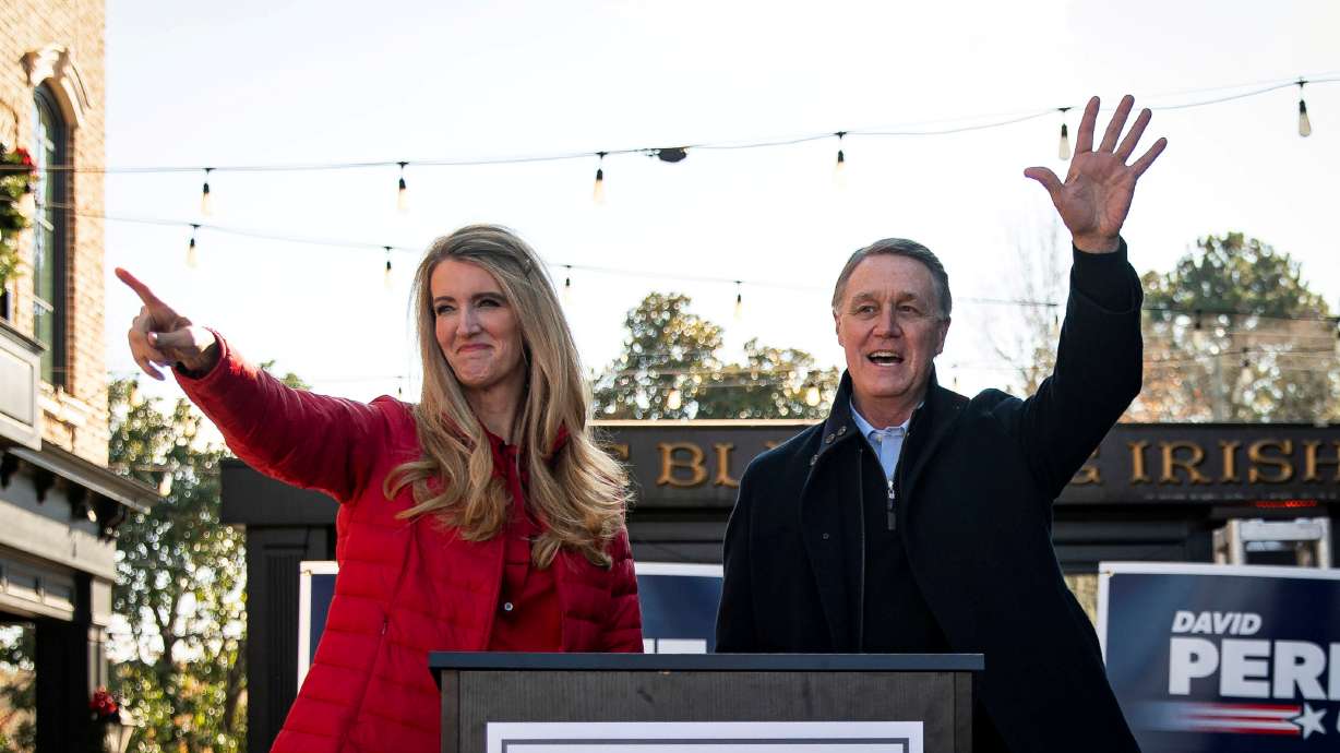 FILE PHOTO: Senator Kelly Loeffler (R-GA) and Senator David Perdue (R-GA), wave during a campaign event at the Olde Blind Dog Irish Pub, in Milton, Georgia, U.S., December 21, 2020.REUTERS/Al Drago/File Photo