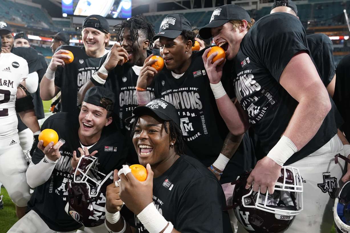 Texas A&M players pose for photos at the end of the Orange Bowl NCAA college football game, Saturday, Jan. 2, 2021, in Miami Gardens, Fla. Texas A&M defeated North Carolina 41-27. (AP Photo/Lynne Sladky)