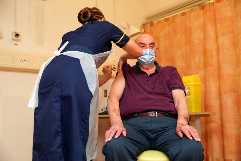 Brian Pinker, 82, receives the Oxford University/AstraZeneca COVID-19 vaccine from nurse Sam Foster at the Churchill Hospital in Oxford, Britain January 4, 2021.