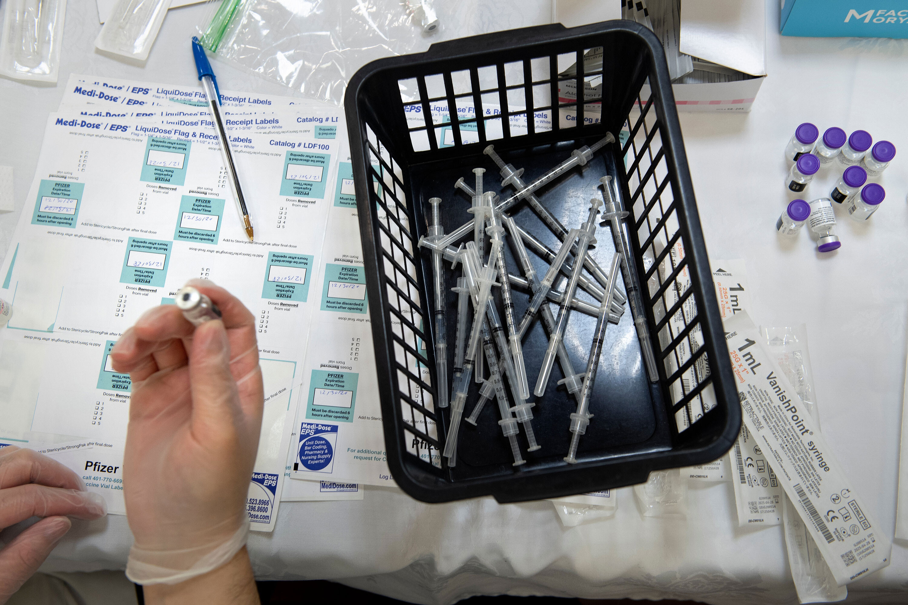 A pharmacist works to dilute the Pfizer COVID-19 vaccine while preparing it to administer to staff and residents at the Goodwin House Bailey's Crossroads, a senior living community in Falls Church, Virginia, on December 30, 2020.