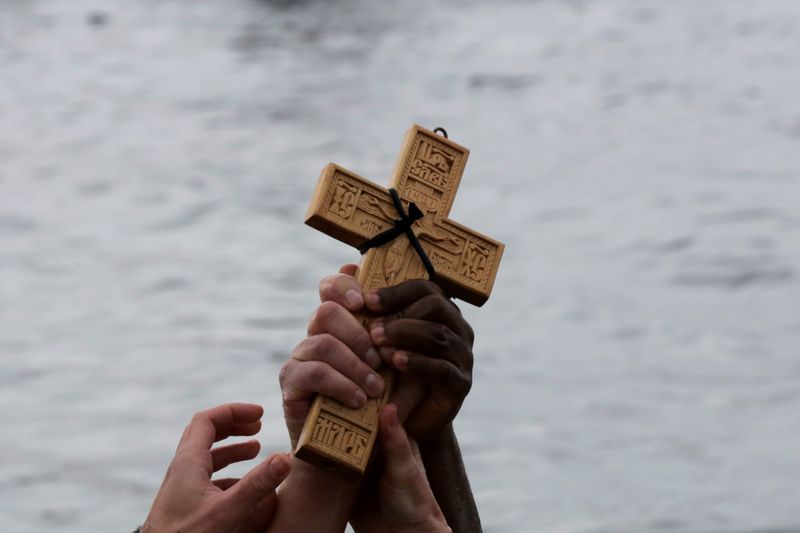 FILE PHOTO: Orthodox faithful raise a wooden crucifix during Epiphany day celebrations in the southern suburb of Faliro in Athens, Greece January 6, 2020. REUTERS/Costas Baltas/File Photo