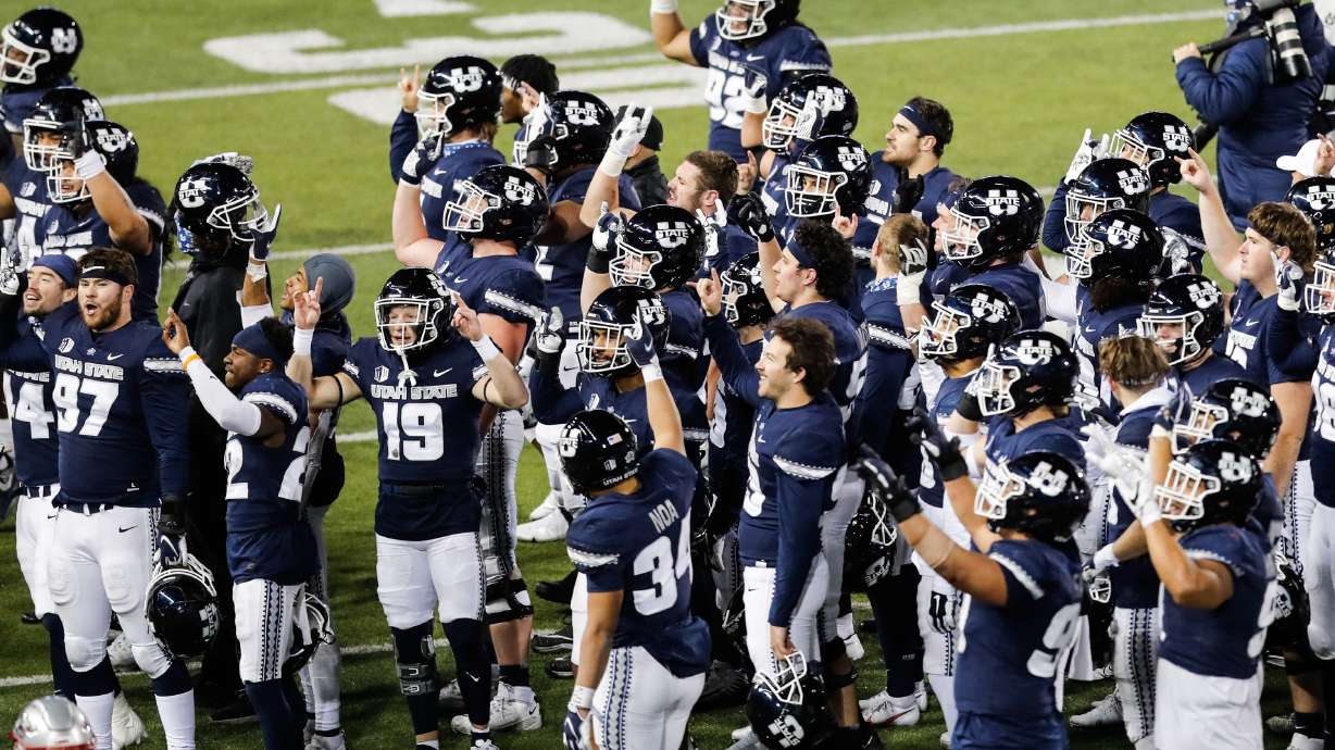 Utah State players greet their families after defeating New Mexico 41-27 at Maverik Stadium in Logan on Thursday, Nov. 26, 2020.
