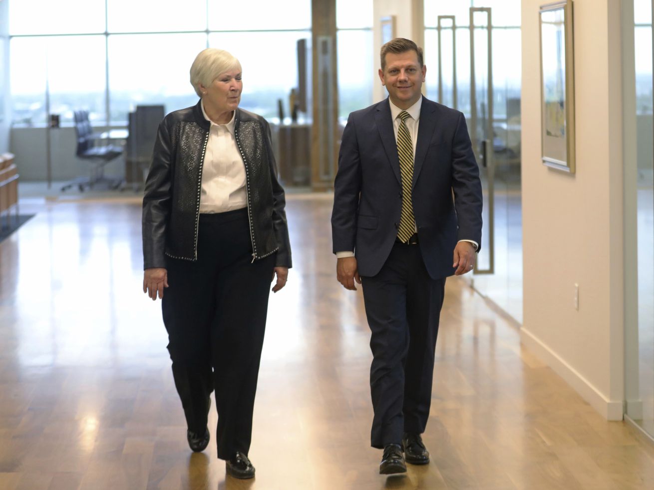 Gail Miller, left, chairwoman and owner of the Larry H.
Miller Group of Companies, and CEO Steve Starks, right, walk
together on Wednesday, Aug. 7, 2019, in Sandy.