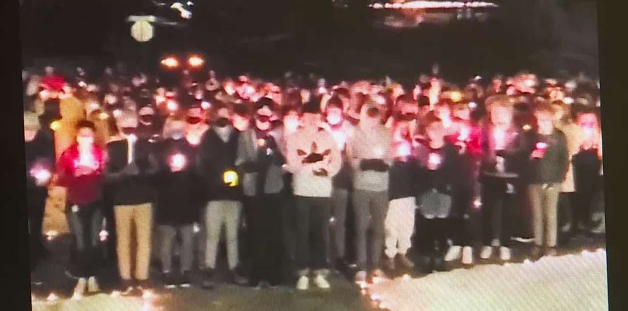 Video still of students who came to Jackson Keate's home Sunday night holding candles.