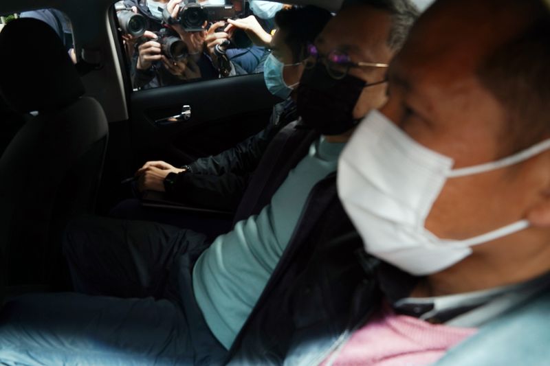 Journalists document through a car window as pro-democracy activist Benny Tai (2nd R) is taken to a police station in Hong Kong, China January 6, 2021.