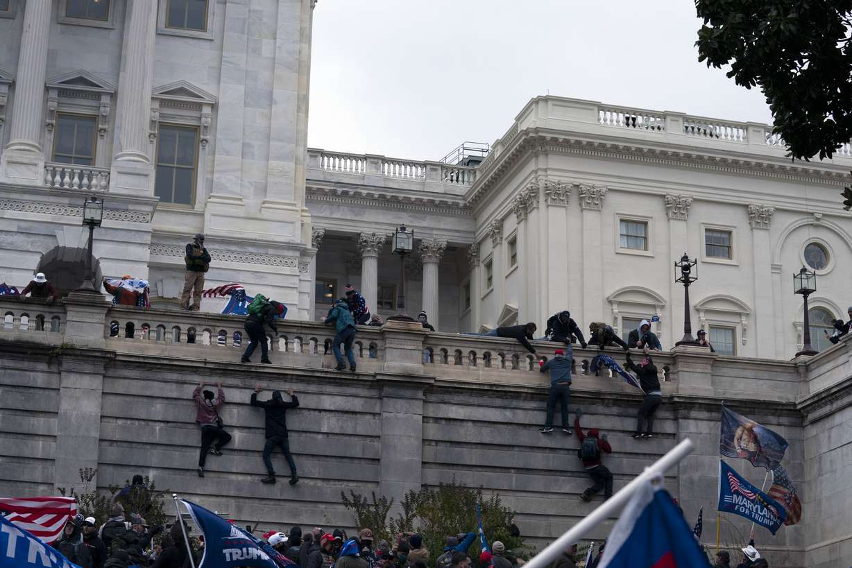 Supporters of President Donald Trump climb the West wall of the the U.S. Capitol on Wednesday, Jan. 6, 2021, in Washington.