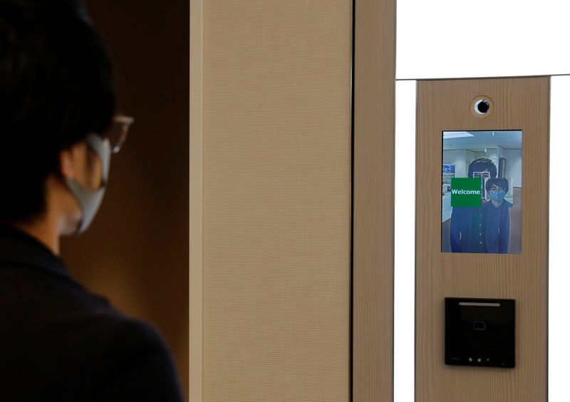 NEC's Shinya Takashima demonstrates a facial recognition system that identifies people even when they are wearing masks, amid the coronavirus disease (COVID-19) outbreak, at its headquarters in Tokyo, Japan, January 6, 2021. Picture taken on January 6, 2021.  REUTERS/Kim Kyung-Hoon