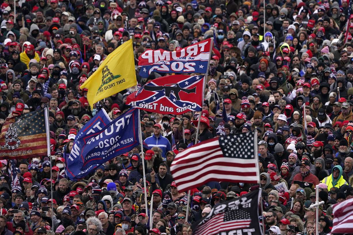 FILE - In this Jan. 6, 2021, file photo, people listen as President Donald Trump speaks during a rally in Washington. The U.S. registered its highest deaths yet from the coronavirus on the same day as a mob attack on the nation’s capitol laid bare some of the same, deep political divisions that have hampered the battle against the pandemic.