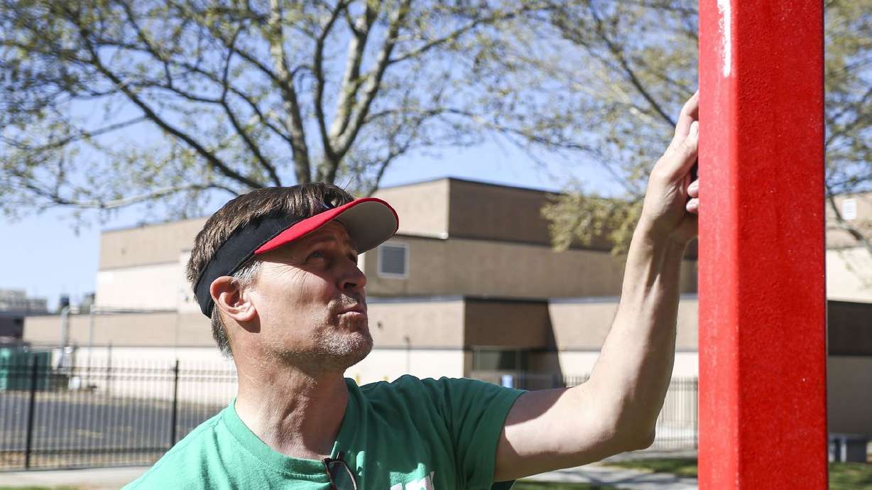 Then-West High School Principal Ford White paints
alongside volunteers from Fidelity Investments at the Salt Lake
City school in this April 27, 2019, file photo.