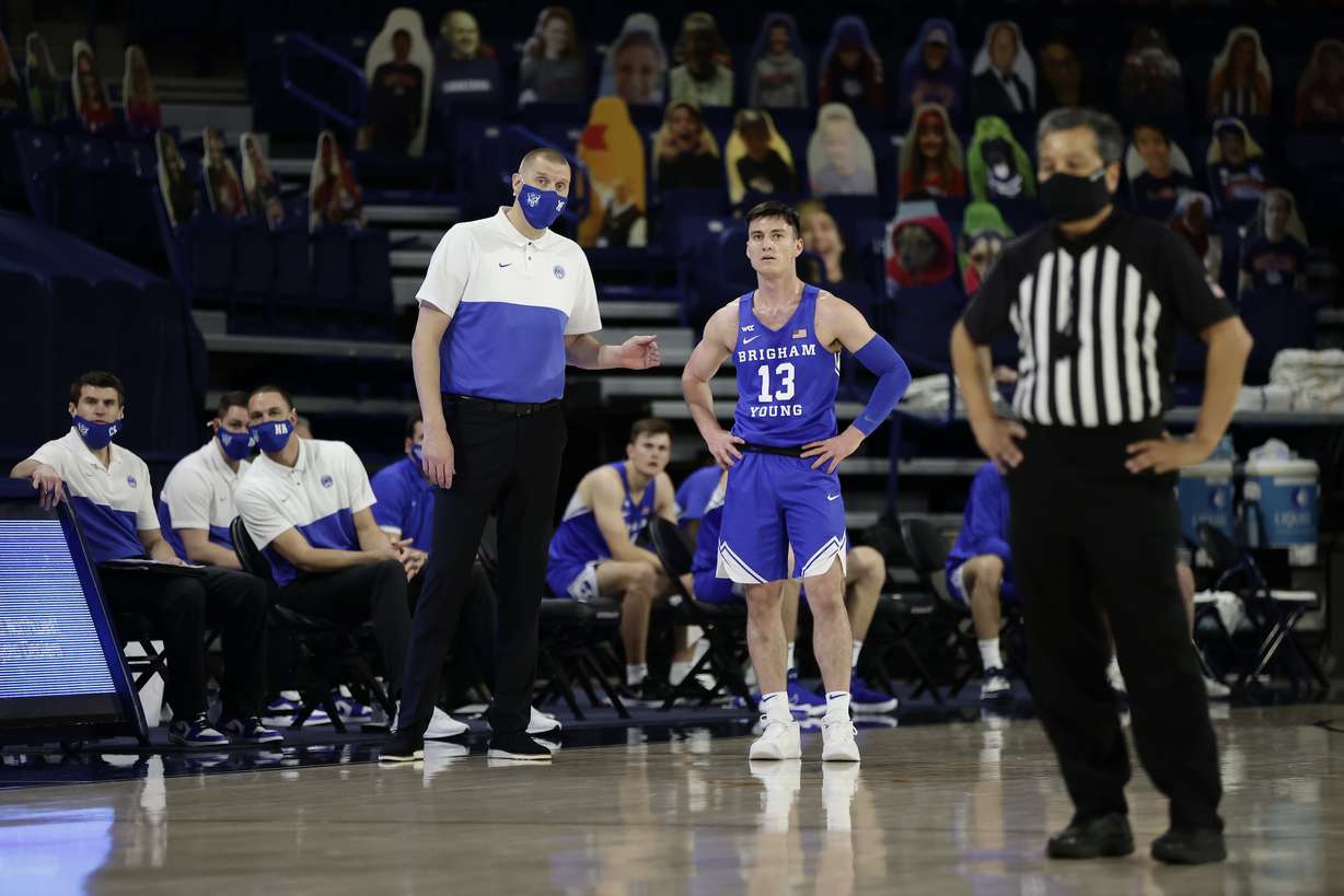 BYU coach Mark Pope, left, and point guard Alex Barcello, look up after falling behind big against No. 1 Gonzaga, Thursday, Jan. 7, 2021, in Spokane, Washington.
