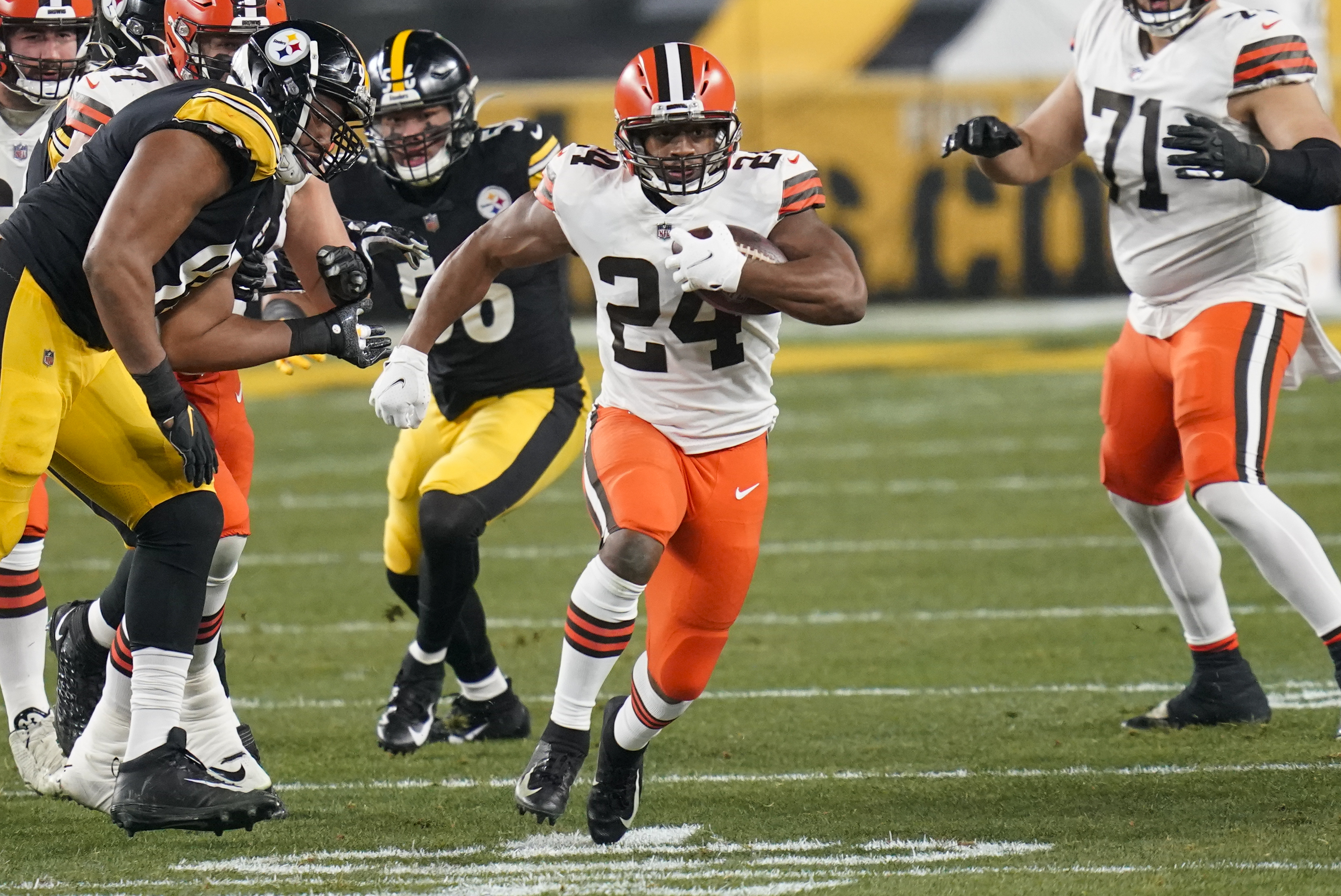 Cleveland Browns running back Nick Chubb (24) runs through a hole during the first half of an NFL wild-card playoff football game against the Pittsburgh Steelers, Sunday, Jan. 10, 2021, in Pittsburgh.