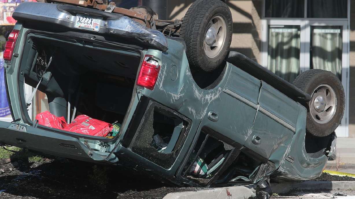 A Ford Explorer sits upside down as West Valley police
and firefighters respond to a fatal rollover on Redwood Road near
3692 South on Sunday, March 31, 2019. A 76-year-old Sandy man was
killed in the crash.