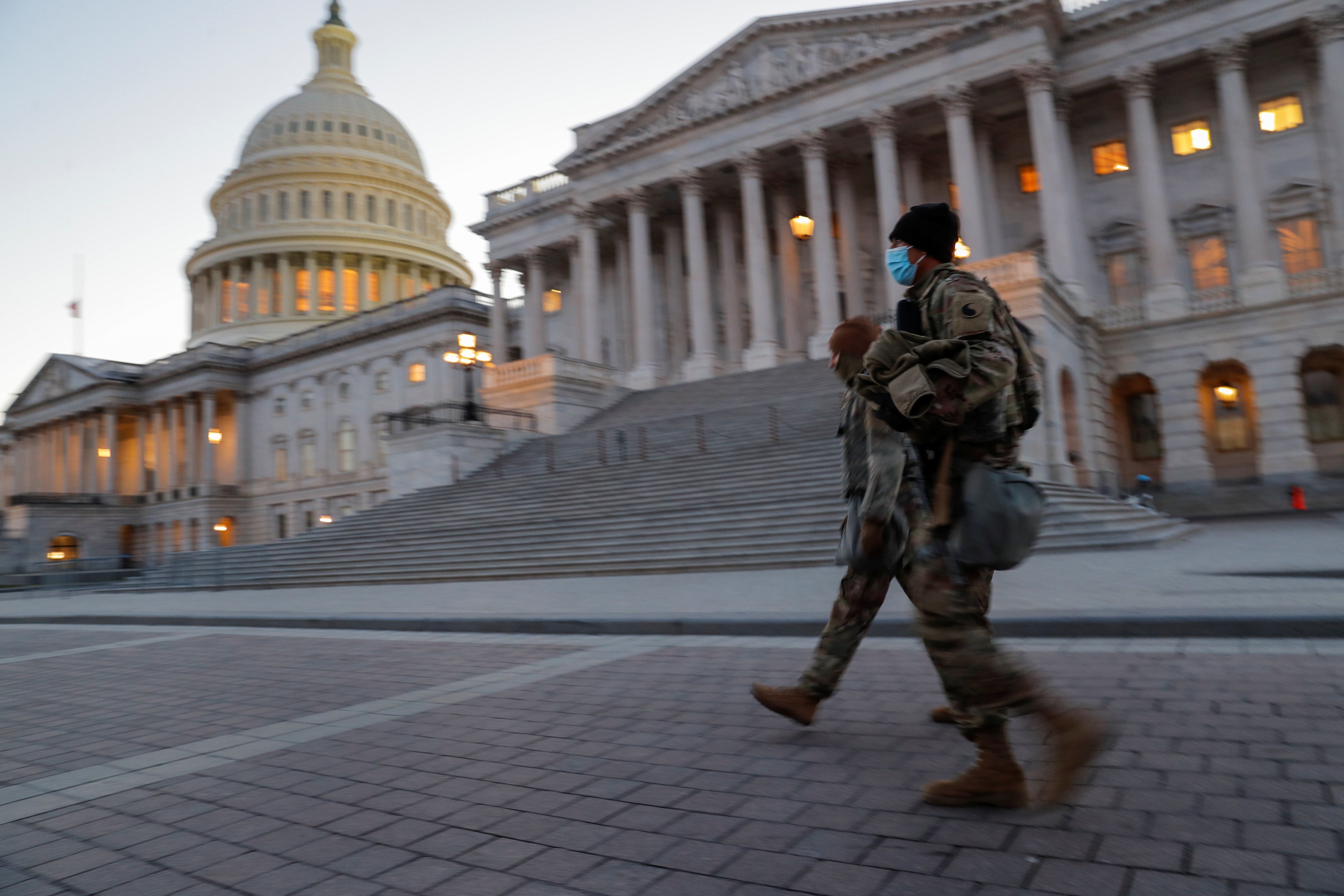 U.S. National Guard members walk near the U.S. Capitol Building on Capitol Hill in Washington, U.S., January 13, 2021.