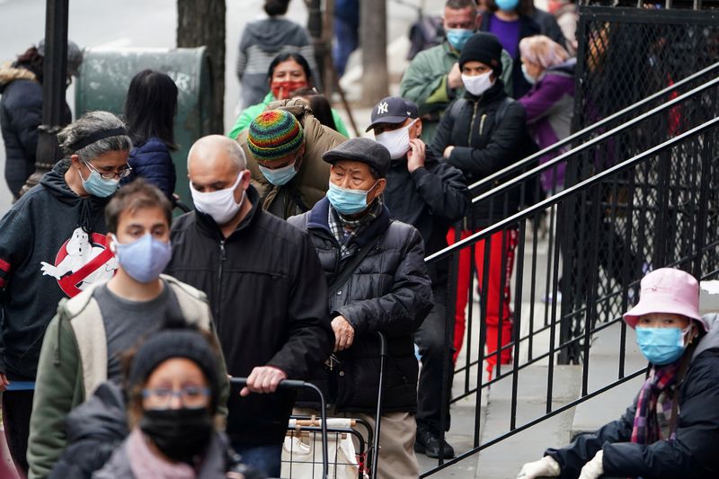 FILE PHOTO: People wait in line at the St. Clements Food Pantry for food during the coronavirus disease (COVID-19) pandemic in the Manhattan borough of New York City, New York, U.S., December 11, 2020. REUTERS/Carlo Allegri/File Photo/File Photo/File Photo