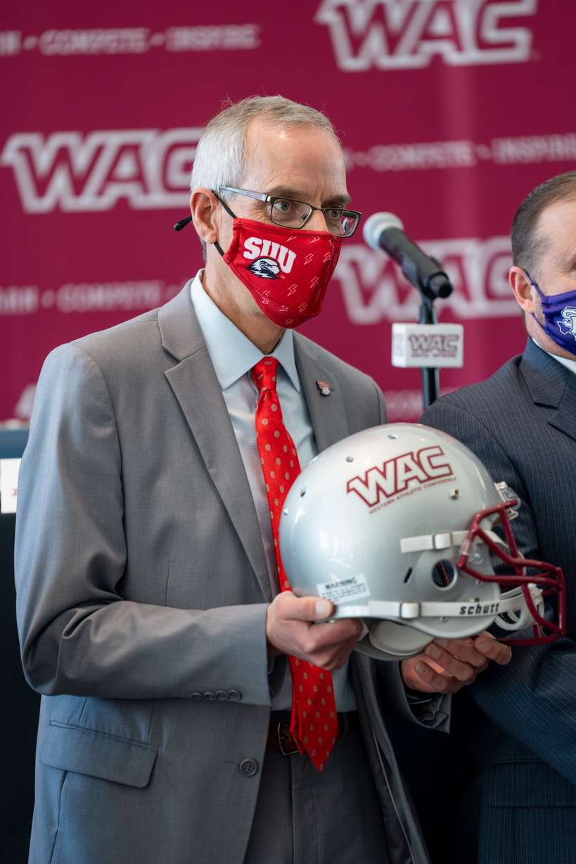 SUU president Scott Wyatt holds a WAC football helmet during a press conference on Thursday.
