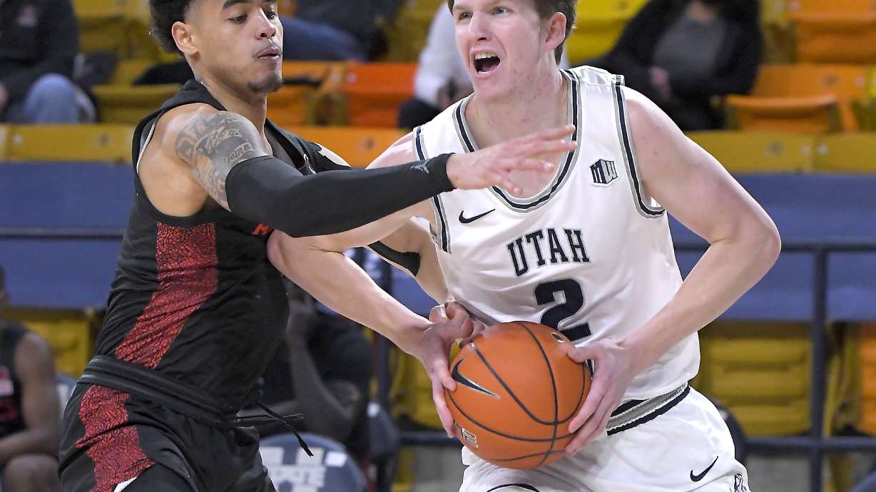 Utah State guard Sean Bairstow (2) drives to the basket as San Diego State guard Trey Pulliam defends during the first half of an NCAA college basketball game Thursday, Jan. 14, 2021, in Logan, Utah. (Eli Lucero/The Herald Journal via AP, Pool)