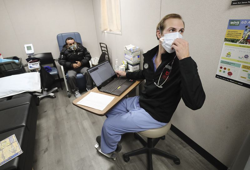 Hope Clinic physician assistant Matt Pierce talks with
a colleague while examining patient Luis Hualinga at the clinic in
Midvale on Wednesday, Jan. 6, 2021. Two bills to be considered by
the Utah Legislature would broaden the role of physician assistants
to let them offer mental health therapy and respond during a health
emergency.
