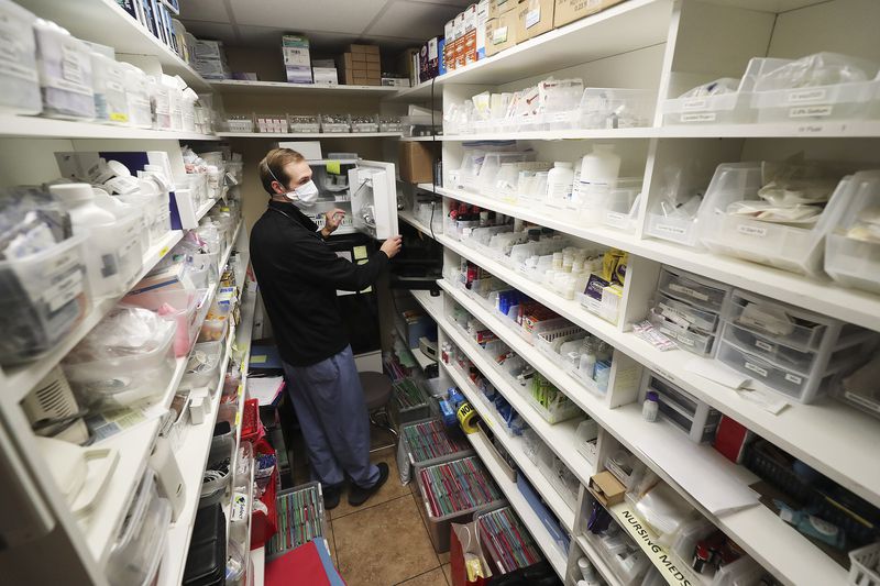 Hope Clinic physician assistant Matt Pierce gathers
medications at the clinic in Midvale on Wednesday, Jan. 6, 2021.
Two bills to be considered by the Utah Legislature would broaden
the role of physician assistants to let them offer mental health
therapy and respond during a health emergency.