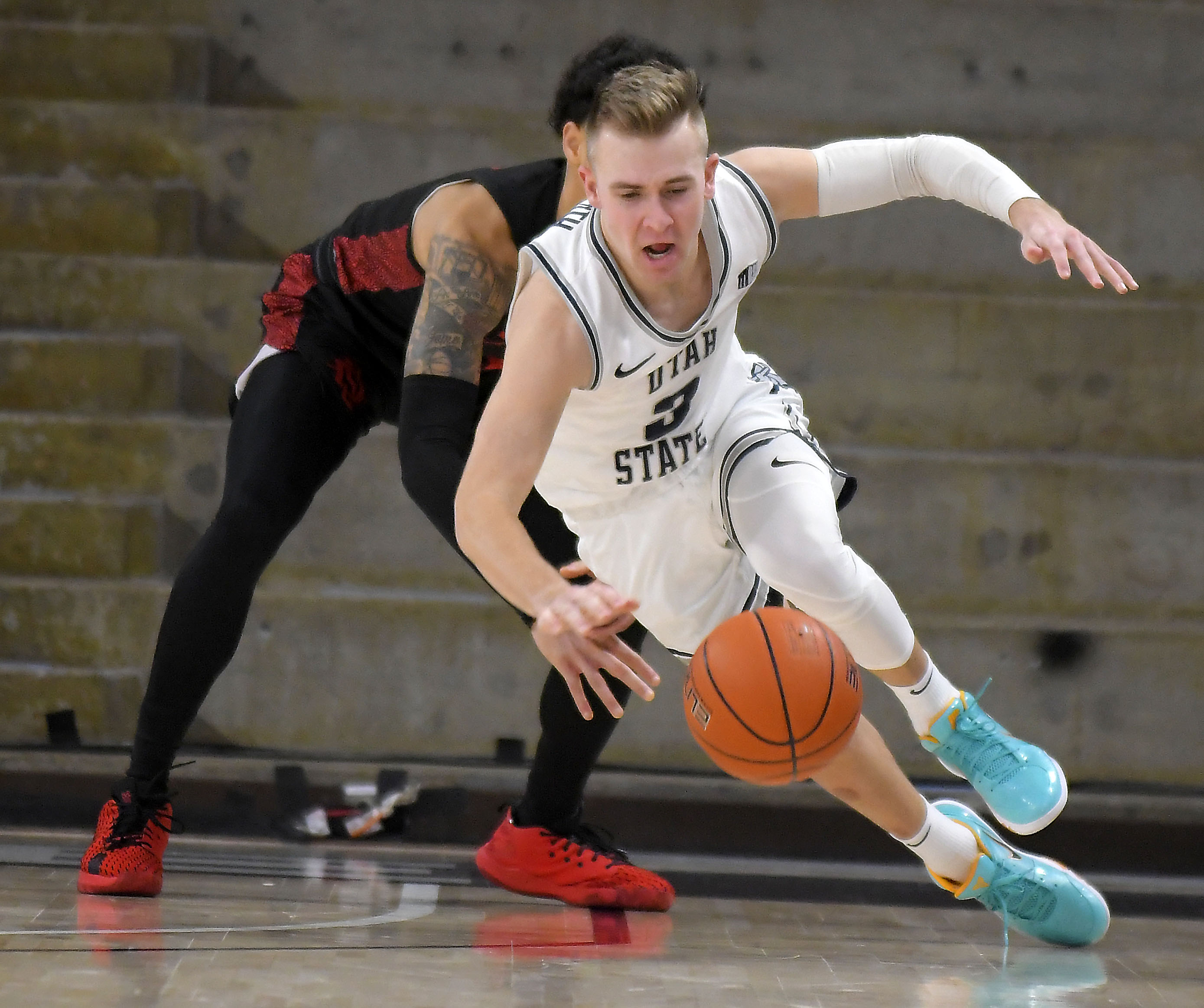Utah State guard Steven Ashworth (3) gets fouled by San Diego State guard Trey Pulliam during the second half of an NCAA college basketball game Saturday, Jan. 16, 2021, in Logan, Utah.