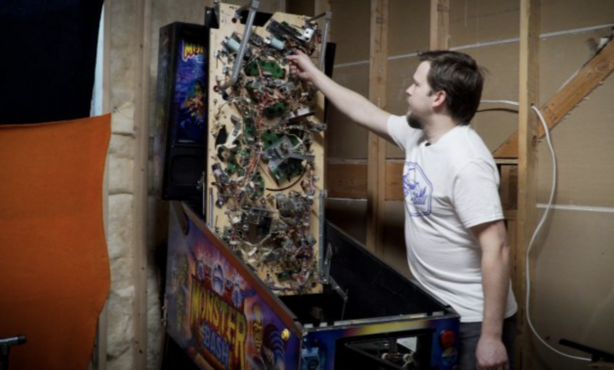 Kelly Thomson shows what the innards of a pinball machine look like.