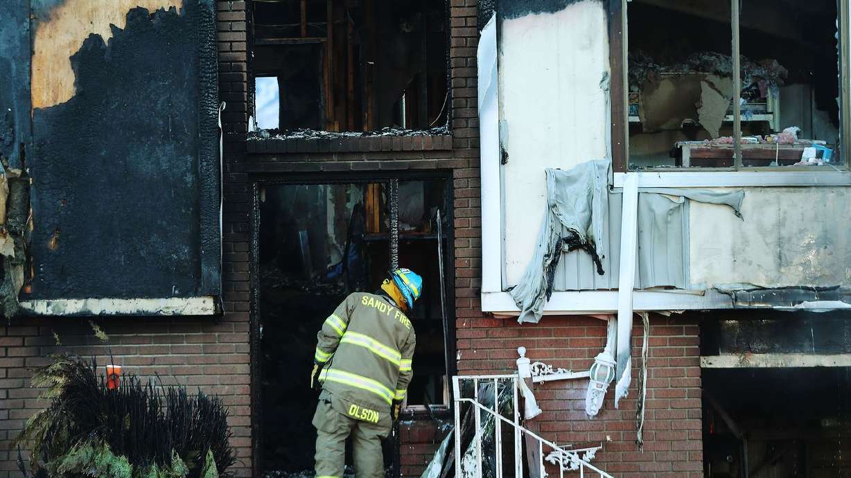 A firefighter looks over the damage from a house fire
at 9681 S. 1485 East in Sandy on Tuesday, Jan. 19, 2021.
