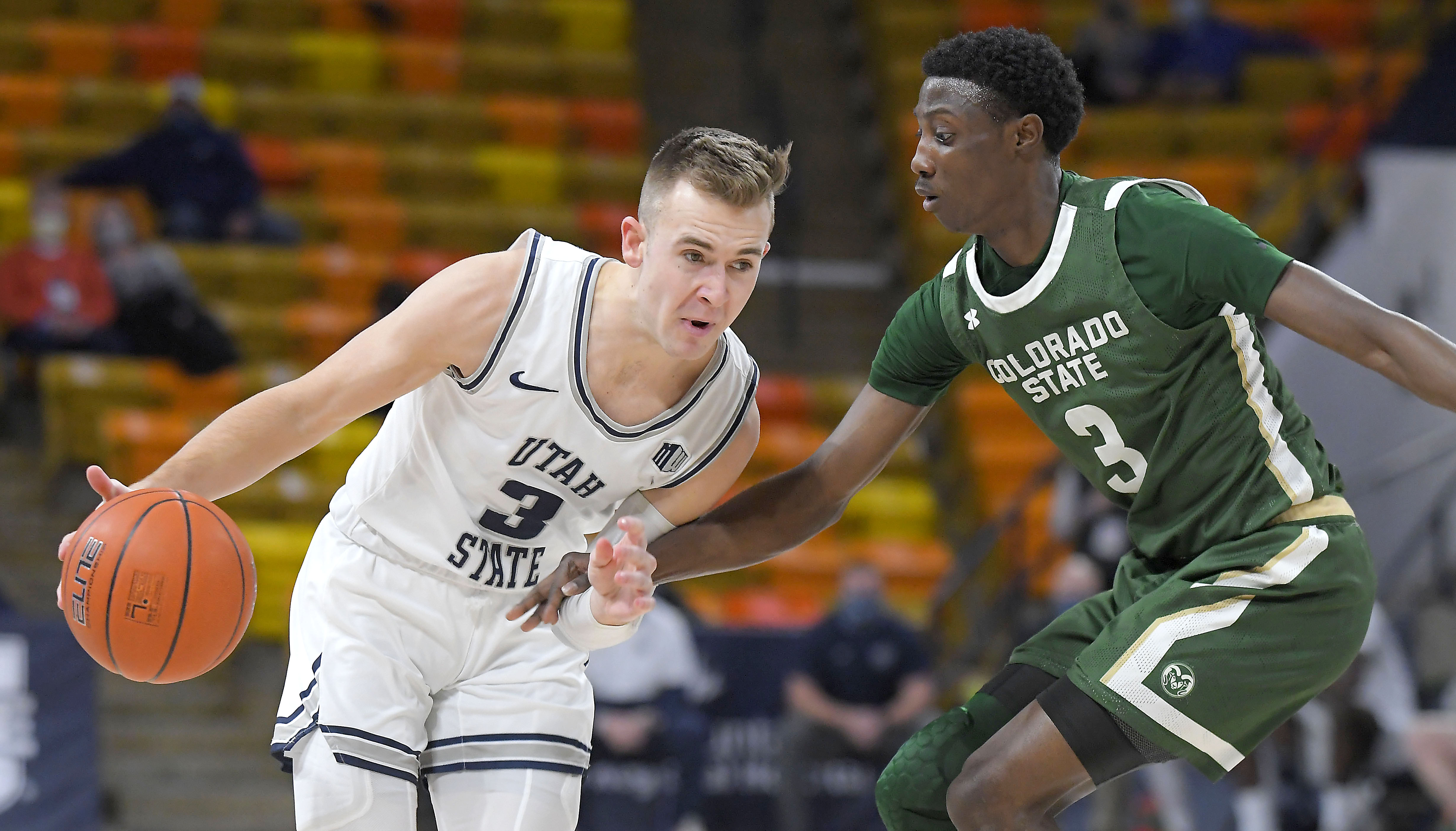 Utah State guard Steven Ashworth, left, dribbles the ball as Colorado State guard Kendle Moore defends during the first half of an NCAA college basketball game Tuesday, Jan. 19, 2021, in Logan, Utah. (Eli Lucero/The Herald Journal via AP, Pool)