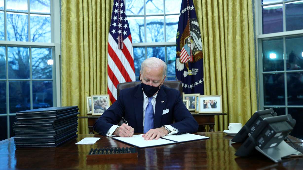 U.S. President Joe Biden signs executive orders in the Oval Office of the White House in Washington, after his inauguration as the 46th President of the United States, U.S., January 20, 2021.