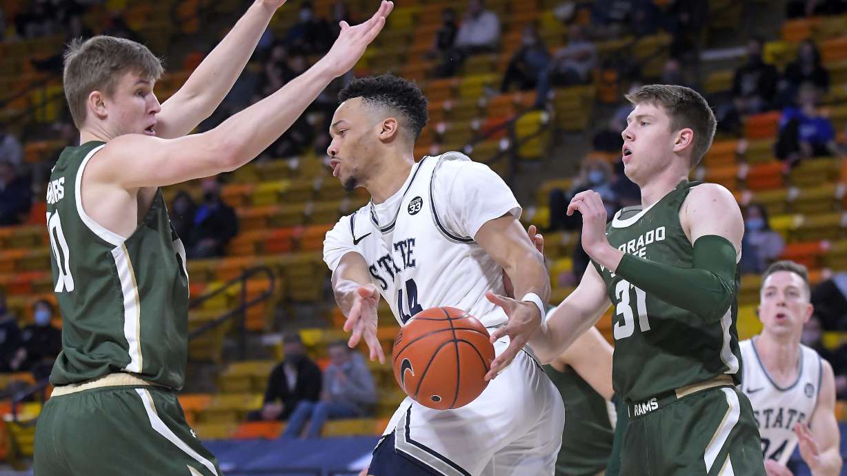 Utah State guard Marco Anthony (44) looks to pass the ball as Colorado State forward James Moors (10) and forward Adam Thistlewood (31) defend during the first half of an NCAA college basketball game Thursday, Jan. 21, 2021, in Logan, Utah. (Eli Lucero//The Herald Journal via AP, Pool)