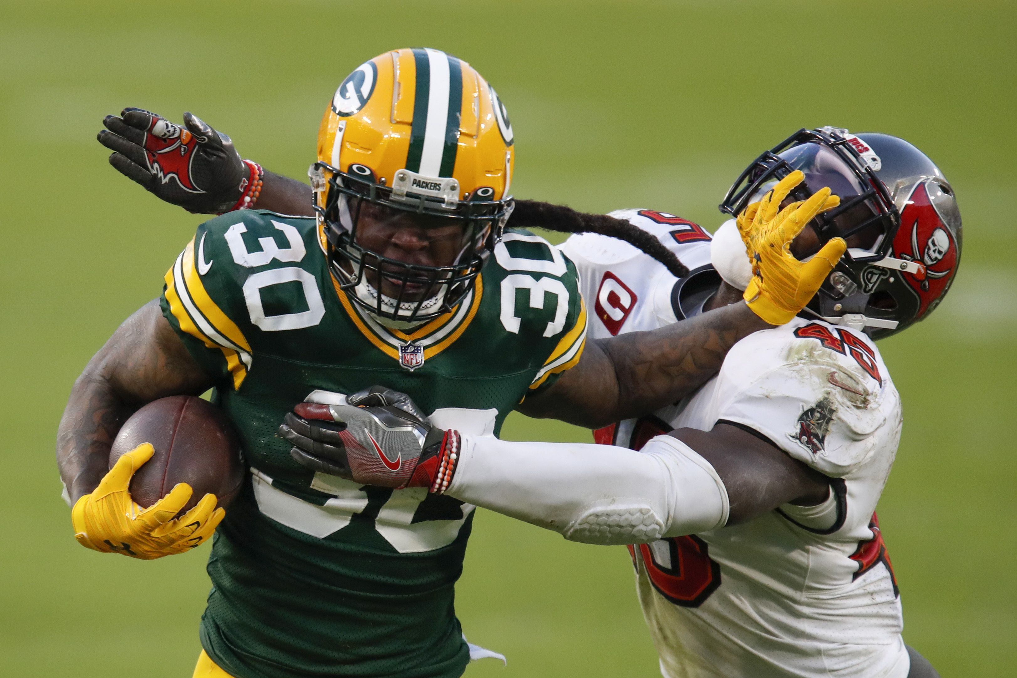 Green Bay Packers' Jamaal Williams pushes off Tampa Bay Buccaneers' Devin White during the second half of the NFC championship NFL football game in Green Bay, Wis., Sunday, Jan. 24, 2021.
