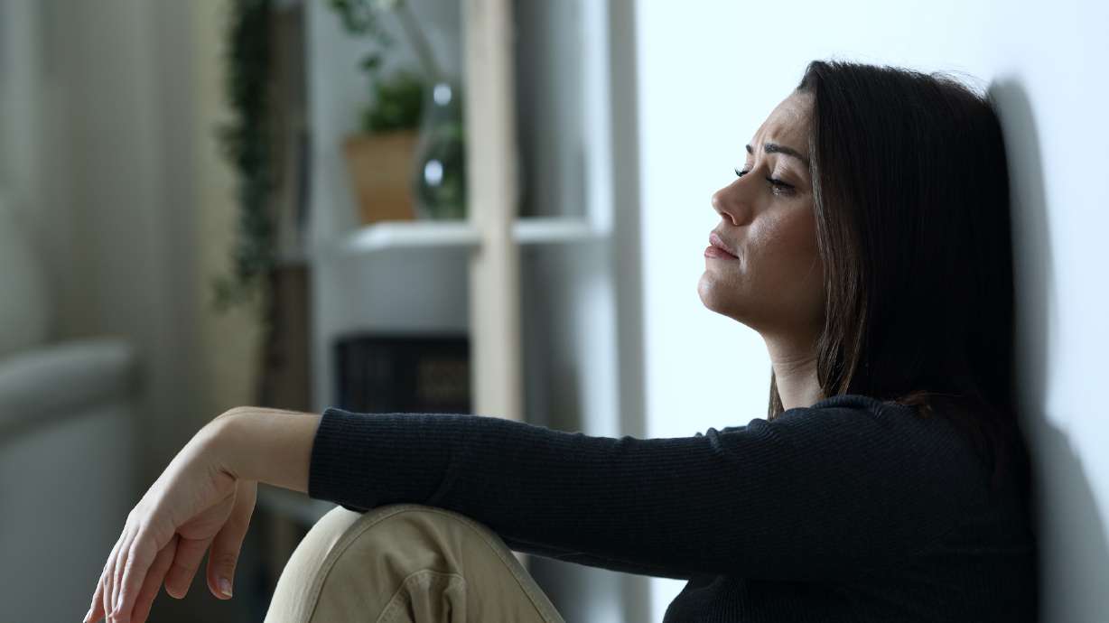 Side view portrait of a sad depressed woman complaining alone at home in the night