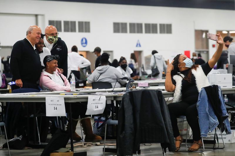 FILE PHOTO: Poll workers pose as votes continue to be counted at the TCF Center the day after the 2020 U.S. presidential election, in Detroit, Michigan, U.S., November 4, 2020.  REUTERS/Shannon Stapleton