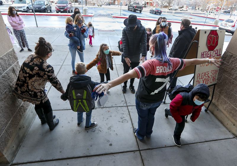 Amber Pedersen, a kindergarten student teacher at
Washington Elementary School, center, practices social distancing
butterfly arms with kindergarten students as they return to
in-person learning for the first time since spring 2020 at the
school in Salt Lake City on Monday, Jan. 25, 2021.