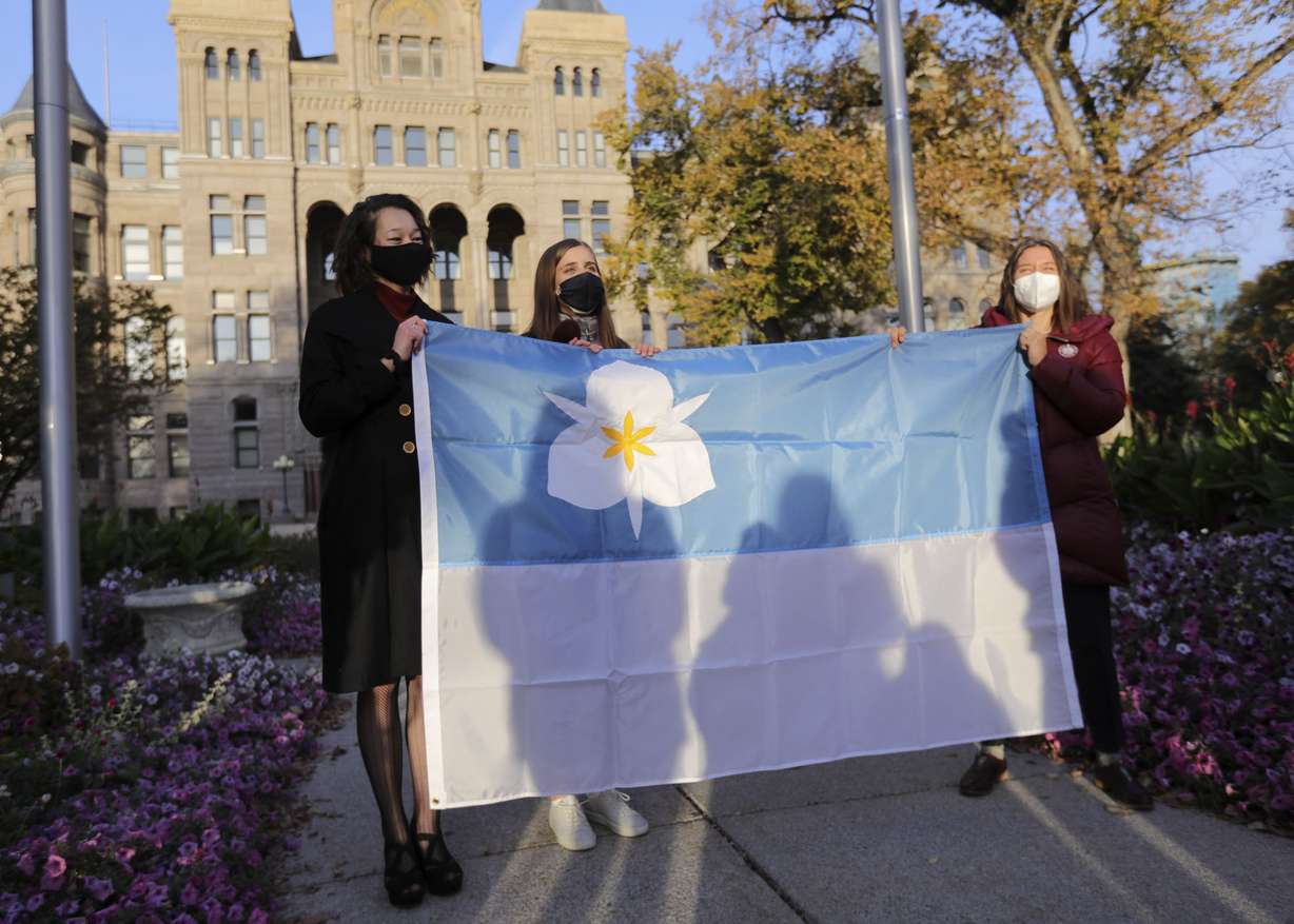 Ella Kennedy-Yoon, left, and Arianna Meinking, co-designers of Salt Lake Cityâs new flag, and Mayor Erin Mendenhall pose for a photo with the flag during a flag-raising ceremony outside of the City-County Building in Salt Lake City on Friday, Oct. 23, 2020. Kennedy-Yoon and Meinkingâs submissions were selected separately and then their designs were combined to create the new flag.