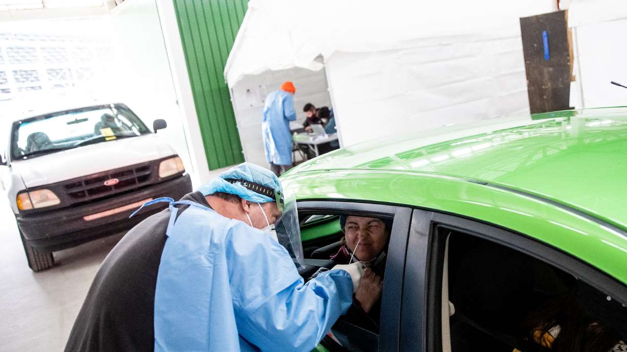 Utah National Guard Sgt. 1st Class Sean Conorich administers a COVID-19 rapid test to Sandy Tiemann at the Fairpark in Salt Lake City on Saturday, Jan. 23, 2021.