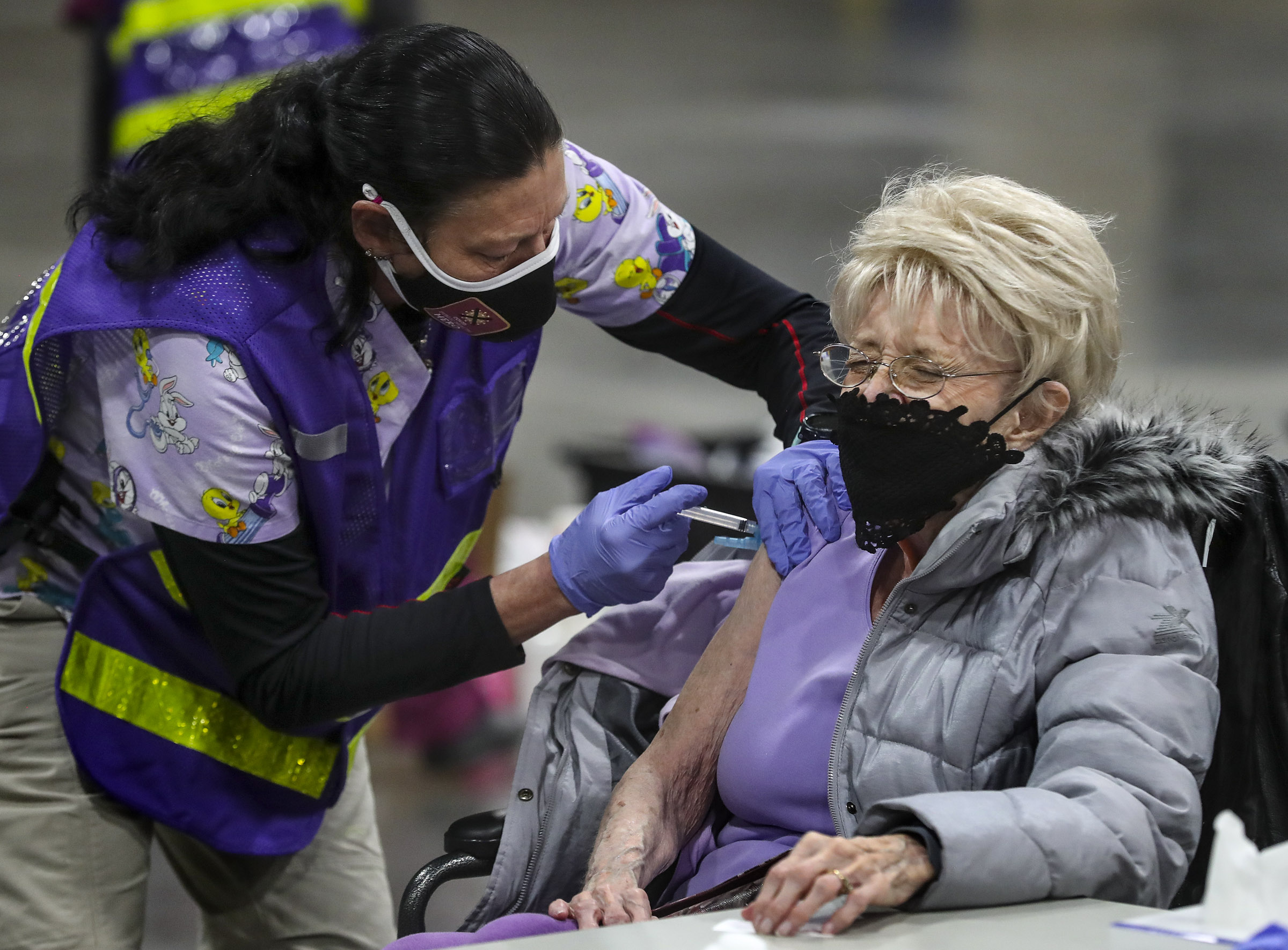 Joyce Durrant closes her eyes tight as Terry Begay, a Salt Lake County Health Department advanced EMT, gives her a COVID-19 vaccine at the countyâ??s mass vaccination site at the Mountain America Expo Center in Sandy on Monday, Jan. 18, 2021. Durrant and her husband, Richard Durrant, were receiving their first doses of the Moderna vaccine.