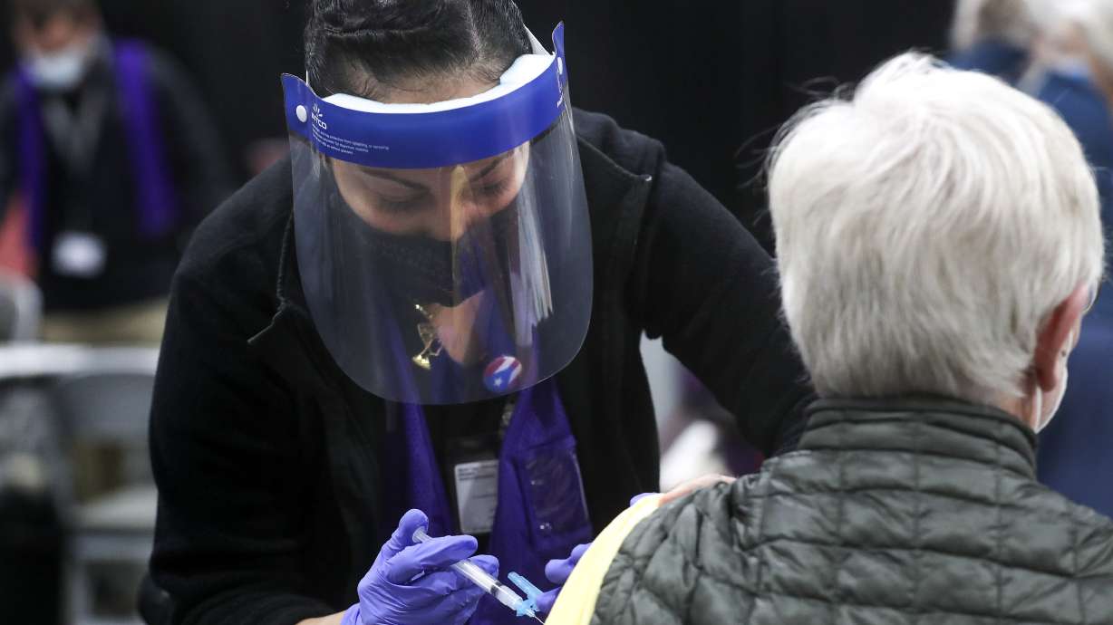 Rosa Valdiziez, a Salt Lake County Health Department nurse, administers a dose of the Moderna COVID-19 vaccine at the county's mass vaccination site at the Mountain America Expo Center in Sandy on Monday, Jan. 18, 2021.
