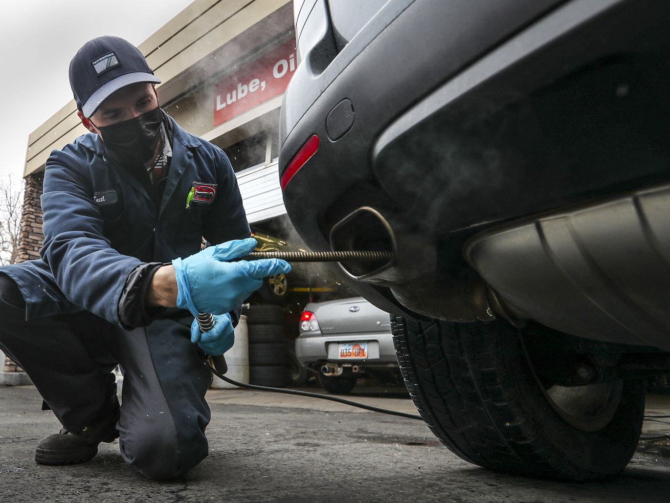 Teal Buchi performs an emission test on a vehicle at
Craig’s Service Center in Salt Lake City on Tuesday, Jan. 26, 2021.