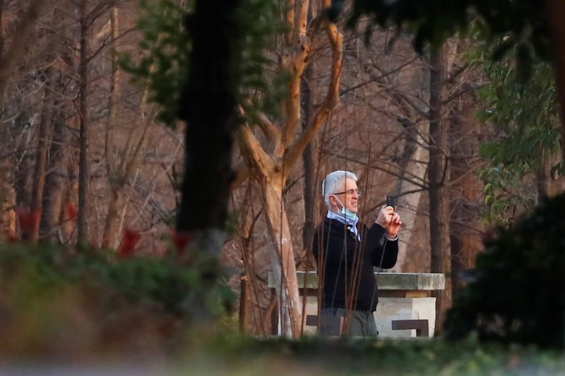 Dominic Dwyer, a member of the World Health Organisation (WHO) team tasked with investigating the origins of the coronavirus disease (COVID-19), uses his mobile phone at a hotel in Wuhan, Hubei province, China January 28, 2021. REUTERS/Thomas Peter